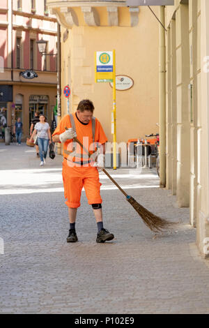 Ein Straßenreiniger mit Strohbeber, der die Straßen in Regensburg säubert. Stockfoto