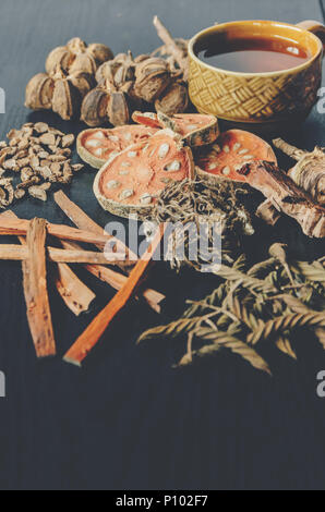 Getrocknete Kräuter und Ginseng, Close-up der thailändischen Kräutern und Ginseng auf Holzboden. Scheiben trocknet Root für ein Kraut Saft auf der dunklen Tisch machen. Stockfoto