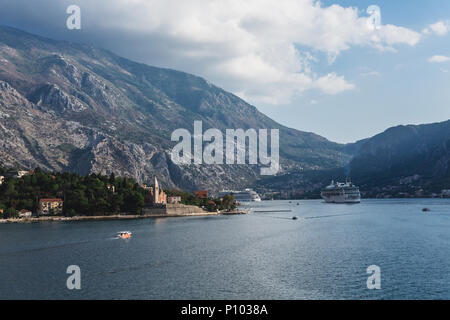 Eine rote Fähre mit Kirche im Hintergrund in der Nähe von Kotor Stockfoto