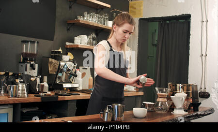 Hände von Barista hinzufügen Salz im Kaffee caramel Stockfoto