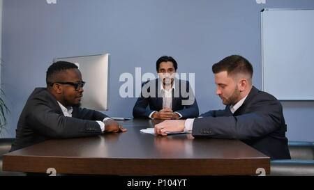 Junge ernsten Mann, Papiere, sie aufmerksam lesen, während der Sitzung im Büro Stockfoto