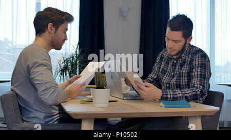Business Partner die Hände schütteln im Büro, Endbearbeitung mit Dokumenten arbeiten Stockfoto