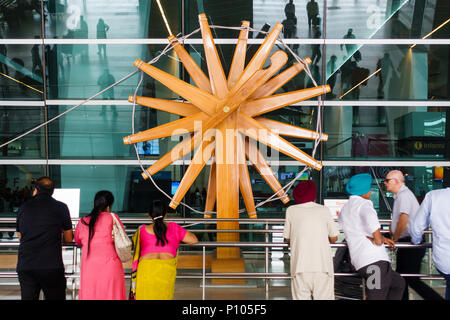 NEW DELHI, INDIEN - ca. April 2017: Menschen stehen vor der weltweit größten charkha (Spinnrad) an Indira Gandhi International Airport. Stockfoto