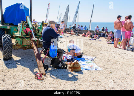 Die Menschen genießen die Sonne am Strand Whitstable, Kent, England, UK. Stockfoto