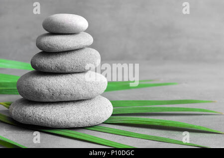 Steine Balance und Green Palm Leaf. Zen und Spa-Konzept. Stockfoto