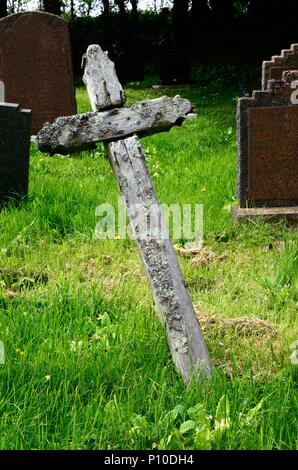 Flechten wachsen auf ein einfaches Holzkreuz grab Marker auf dem Friedhof der Kirche St. Decumans Rhoscrowther Pembrokeshire Wales Cymru GROSSBRITANNIEN Stockfoto