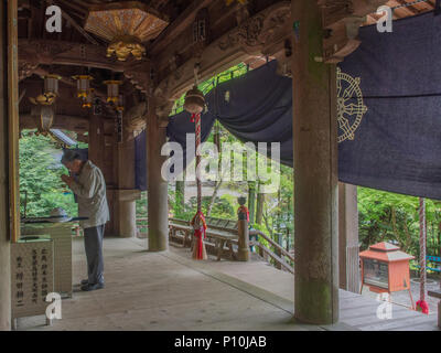 Mann, der betet die Anbetung im Tempel 45 Iwayaji, Shikoku 88 Tempel Wallfahrt, Ehime, Japan Stockfoto