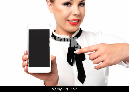 Mobile Technologie Werbung Konzept Bild - elegante Frau, die in förmlichen Business Kleidung mit perfekten Fingernägeln holding Smartphone mit leeren Bildschirm. Stockfoto