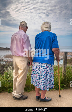 Ein älteres Ehepaar die Sonne nach unten gehen zusammen. Stockfoto