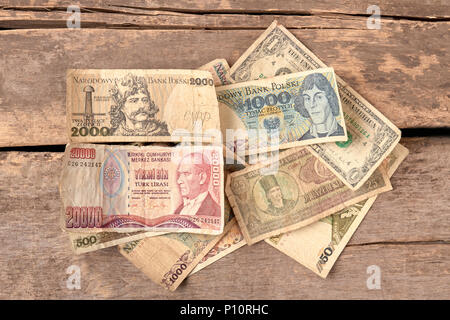 Bunte alte Welt Papiergeld Holzschreibtisch Hintergrund. Stockfoto