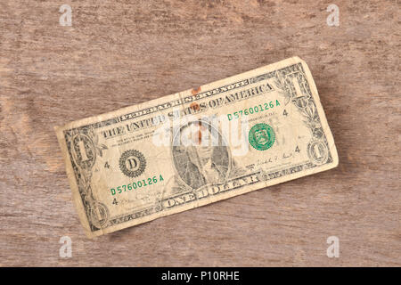 Ein Dollar Scheine auf einem hölzernen Hintergrund. Alt, dreckig abgenutzt Banknote. Ansicht von oben. Stockfoto