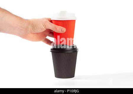 Männliche Hand rot Kunststoff Kaffeetasse auf Schwarz auf weißem Hintergrund mit Kopie Raum isoliert Stockfoto