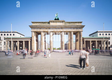 Menschen strömen durch das Brandenburger Tor in Berlin an einem sonnigen Frühlingstag Stockfoto