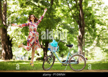 Mädchen springen in der Nähe ihrer Vintage Fahrrad im Park Stockfoto