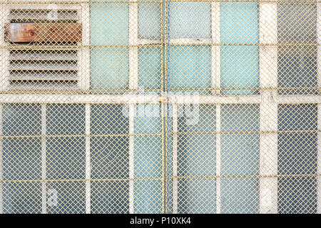 Schließen der Fenster auf alten industriellen Lager, mit draht zaun gesichert. Stockfoto