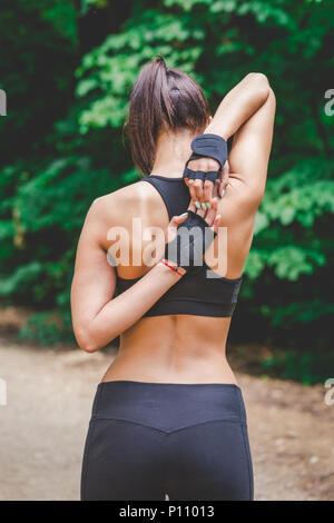 Weibliche Jogger stretching Arme und zurück in die Natur. Stockfoto