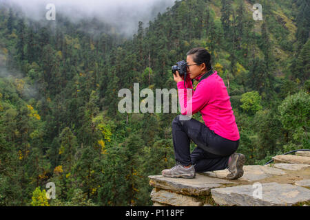Pokhara, Nepal - Oct 22, 2017. Eine junge Frau sitzen und genießen auf der nebligen Karstgebirge. Stockfoto