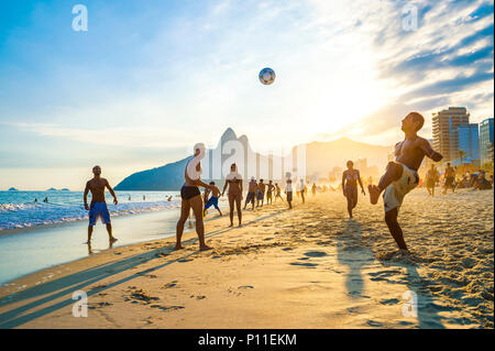 RIO DE JANEIRO - April 01, 2014: Der junge Brasilianer spielen Keepy Uppy, oder altinho, bei Sonnenuntergang am Ufer des Ipanema Strand am Posto 9. Stockfoto