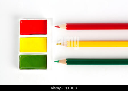 Rot Gelb und Grün leuchtende Aquarell Pfannen und scharfen Buntstifte auf weißem Hintergrund Stockfoto