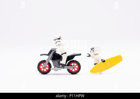 Mini Abbildung von Storm troopers reiten Motorrad mit einer von Ihnen halten surfen Brett ihn jagen. Lego Minifiguren sind von der Lego Gro hergestellt Stockfoto
