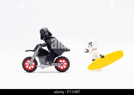 Mini Abbildung von Storm Trooper holding Surfen board jagen Darth Vader reiten Motorrad. Lego Minifiguren sind von der Lego Gruppe hergestellt. Stockfoto