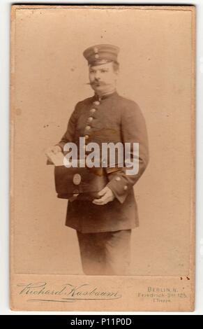 BERLIN, DEUTSCHLAND - ca. 1895: Vintage cabinet Karte zeigt Mann trägt ein briefträger Uniform. Antik schwarz weiß Foto. Stockfoto