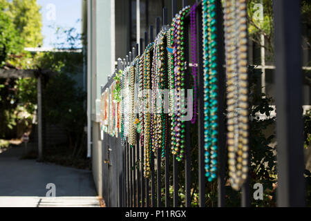 Mardi Gras Perlen hängen an einem schmiedeeisernen Tor in New Orleans, Louisiana. Stockfoto