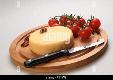 Kleiner Käse Rad neben Kirschtomaten Stockfoto