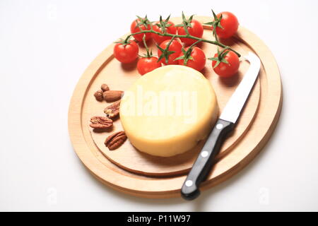 Kleiner Käse Rad neben Kirschtomaten Stockfoto