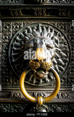 Die Türen des Doms in Köln sind aus Bronze gefertigt. Einen Löwenkopf ist ein türklopfer. Stockfoto