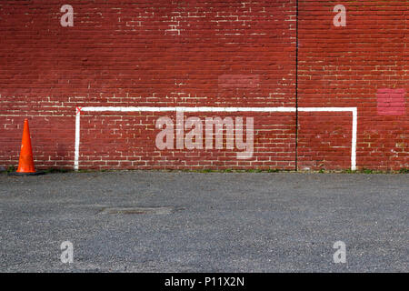 Fußball Torpfosten, nördlich von London, England, Großbritannien - 20 März 2018: Bemalte Torpfosten Graffiti auf Redbrick Wand mit Orange Leitkegel Stockfoto