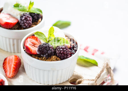 Crumble Kuchen mit Berry mix, Müsli und Eis. Stockfoto