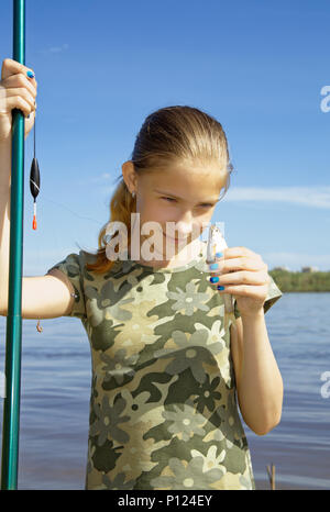 Angeln als Hobby. Mädchen mit der Ironie fing sie an die kleinen Fische suchen, auf dem Gesicht konzentrieren Stockfoto