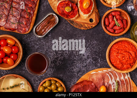 Typische spanische Tapas Konzept. Konzept gehören Scheiben Schinken, Chorizo, Wurst, Schüsseln mit Oliven, Tomaten, Sardellen, pürierte Kichererbsen, Käse. Stockfoto