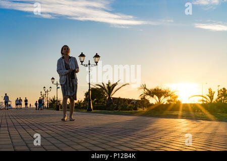 Sotschi, Russia-June 9, 2018: Die Menschen laufen entlang der Imeretinskaya Bahndamm bei Sonnenuntergang. Stockfoto