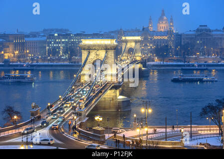 Autos Überqueren einer viel befahrenen Kettenbrücke in Budapest im Winter mit Schnee Stockfoto