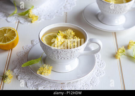 Linden Blumen in einer Tasse Kräutertee auf einem weißen Tisch Stockfoto