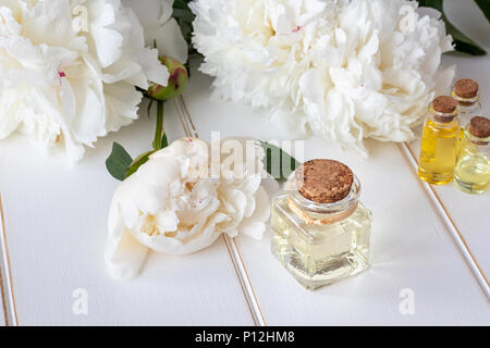 Eine Flasche Öl mit weiße Pfingstrose Blüten Stockfoto