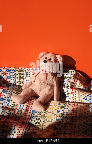 Kleine Teddybär auf Kinderbett Stockfoto