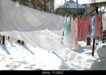 Wäsche aufhängen auf einfache Wäscheleine im Hof, im Winter Stockfoto