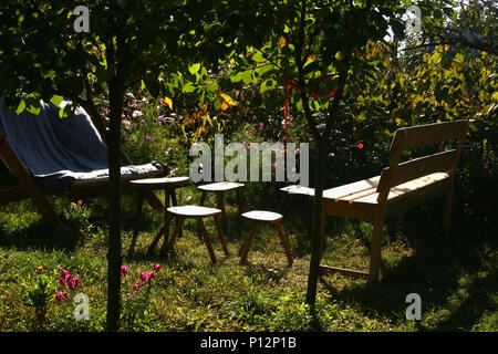 Einfache hölzerne Gartenmöbel im Garten Stockfoto