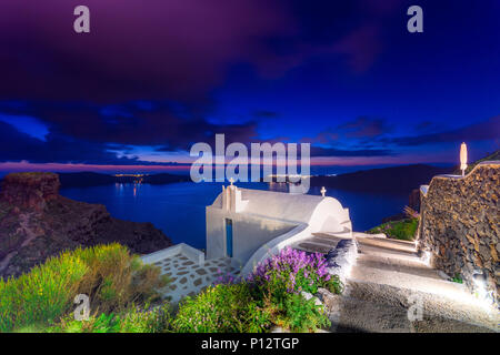Weiße Kirche auf dem Berg Skaros Imerovigli, Santorin, Kreta, Griechenland in der Dämmerung. Stockfoto