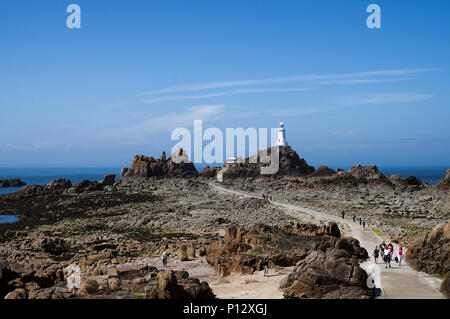 Touristen über den Causeway nach La Corbière Lighthouse in St. Brelade, Jersey, Channel Islands Stockfoto