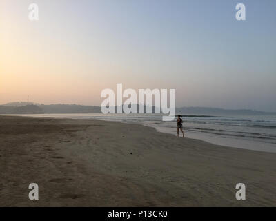 Ein junger Tourist ist Jogging am Strand bei Sonnenaufgang in Weligama Bay, Sri Lanka Stockfoto