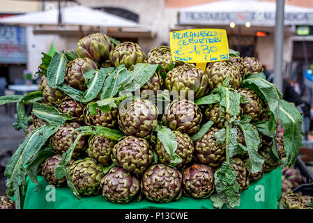 Tabelle der grün und lila Artischocken für Verkauf an den Campo de' Fiori Open-Air-Markt in Rom, beliebter Ort, um frische Produkte in der Innenstadt zu kaufen. Stockfoto