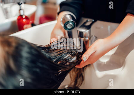 Friseur Hände wäscht die Haare, Nahaufnahme, Friseursalon. Professionelle Haarpflege, Beauty Studio Stockfoto