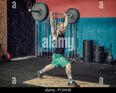 Junger Mann training Beine in der Turnhalle Stockfoto