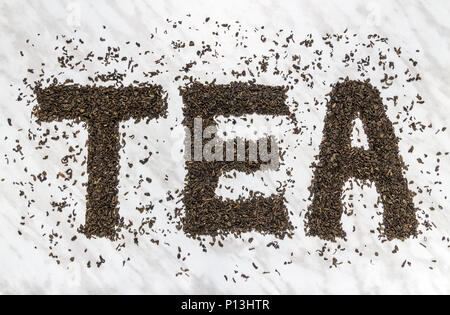 Das Wort "Tee" mit Gunpowder Grüner Tee Blätter geschrieben, auf Marmor Hintergrund. Stockfoto