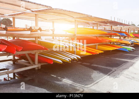 Im Sonnenlicht, Rot, Gelb und Weiß Kajaks platziert mit der Oberseite nach unten auf Metall Lagerregale. Gefüllte Kanu in Brest, Frankreich, 28. Mai 2018. Stockfoto