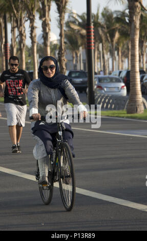 Saudische Frau auf einem Fahrrad in Jeddah, Saudi-Arabien Stockfoto